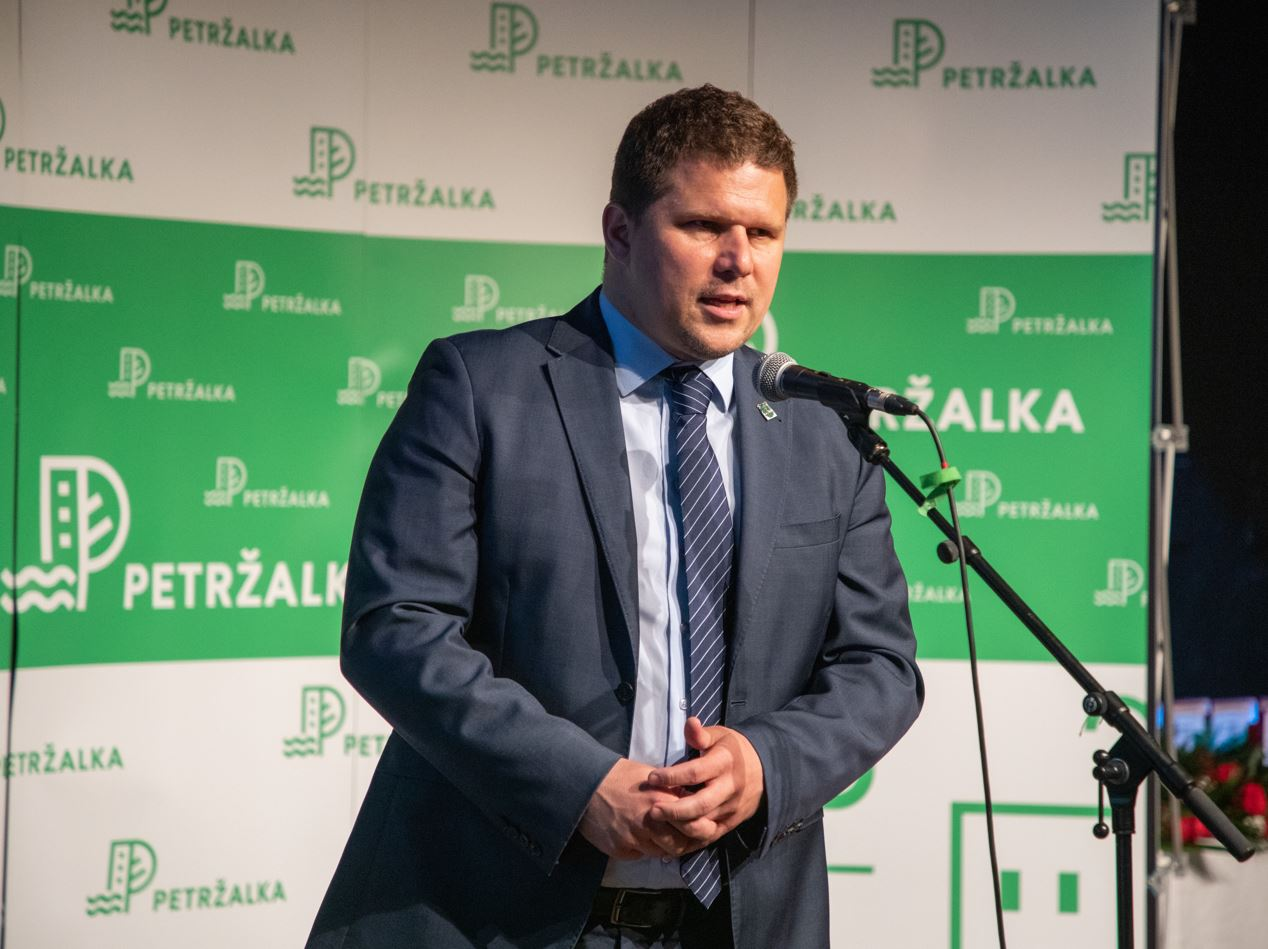 Starosta Petržalky pri mikrofóne pred logom mestskej časti Petržalka